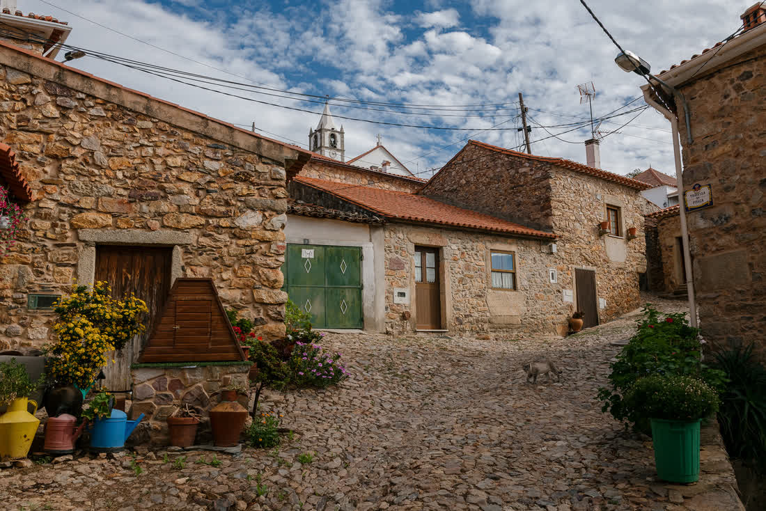 A narrow cobbled street through a Portuguese stone village